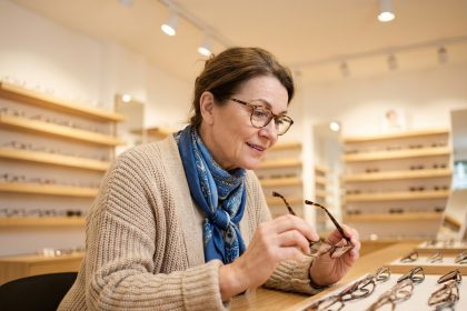 Femme d'&acirc;ge moyen regardant des lunettes modernes en boutique